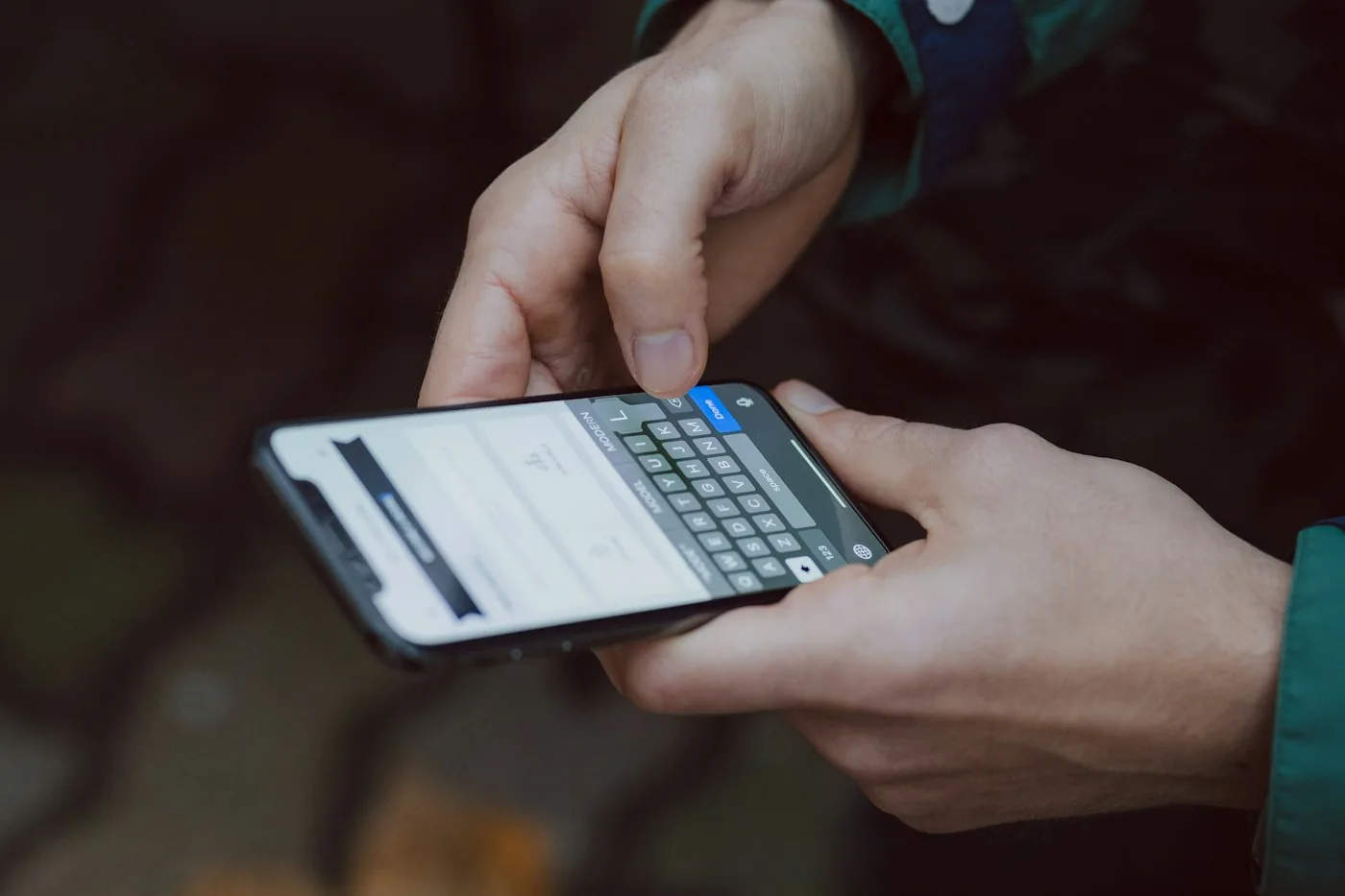 Manos escribiendo un mensaje en un celular