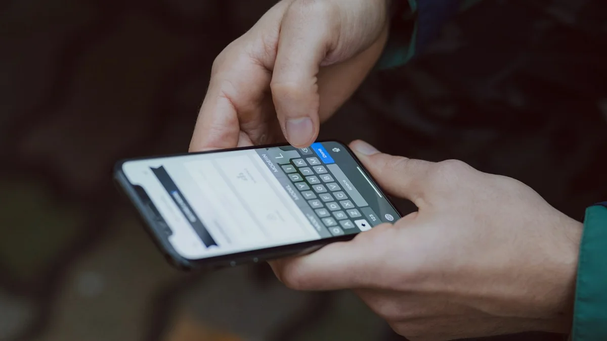 Manos escribiendo un mensaje en un celular