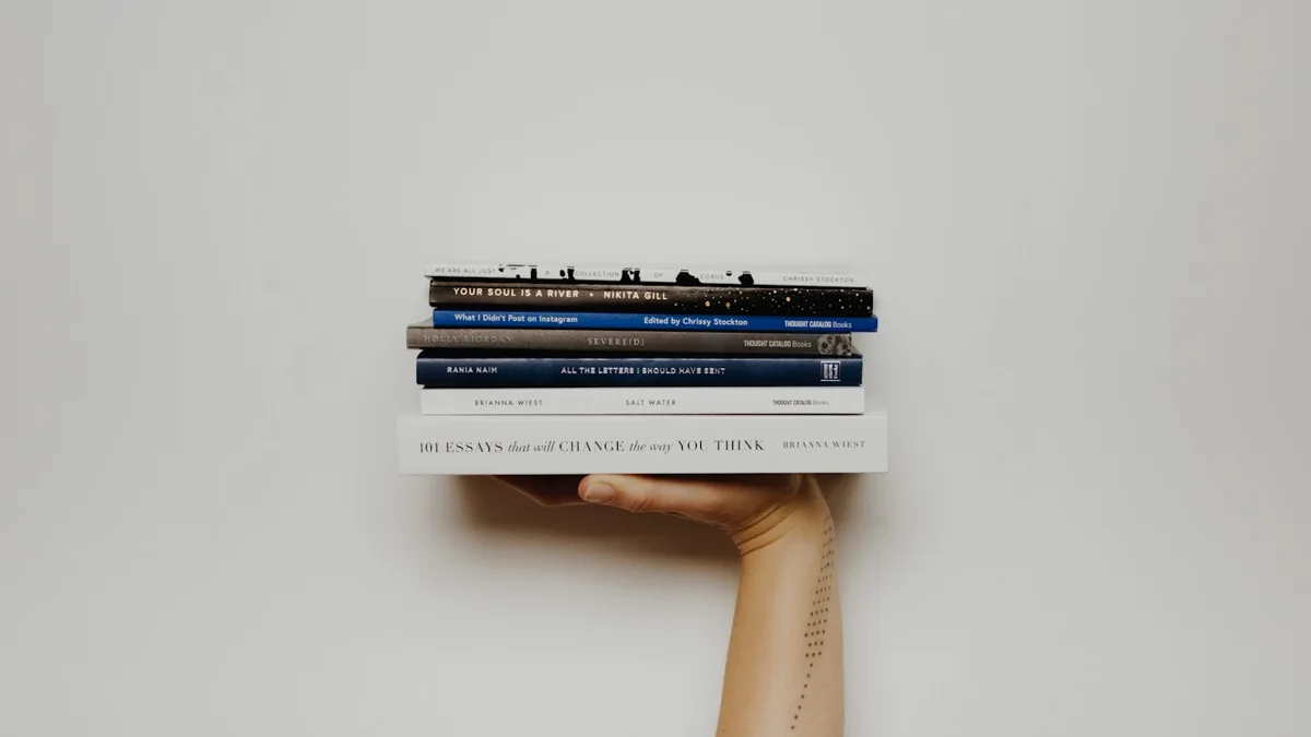 Mano sosteniendo una pila de libros sobre fondo claro