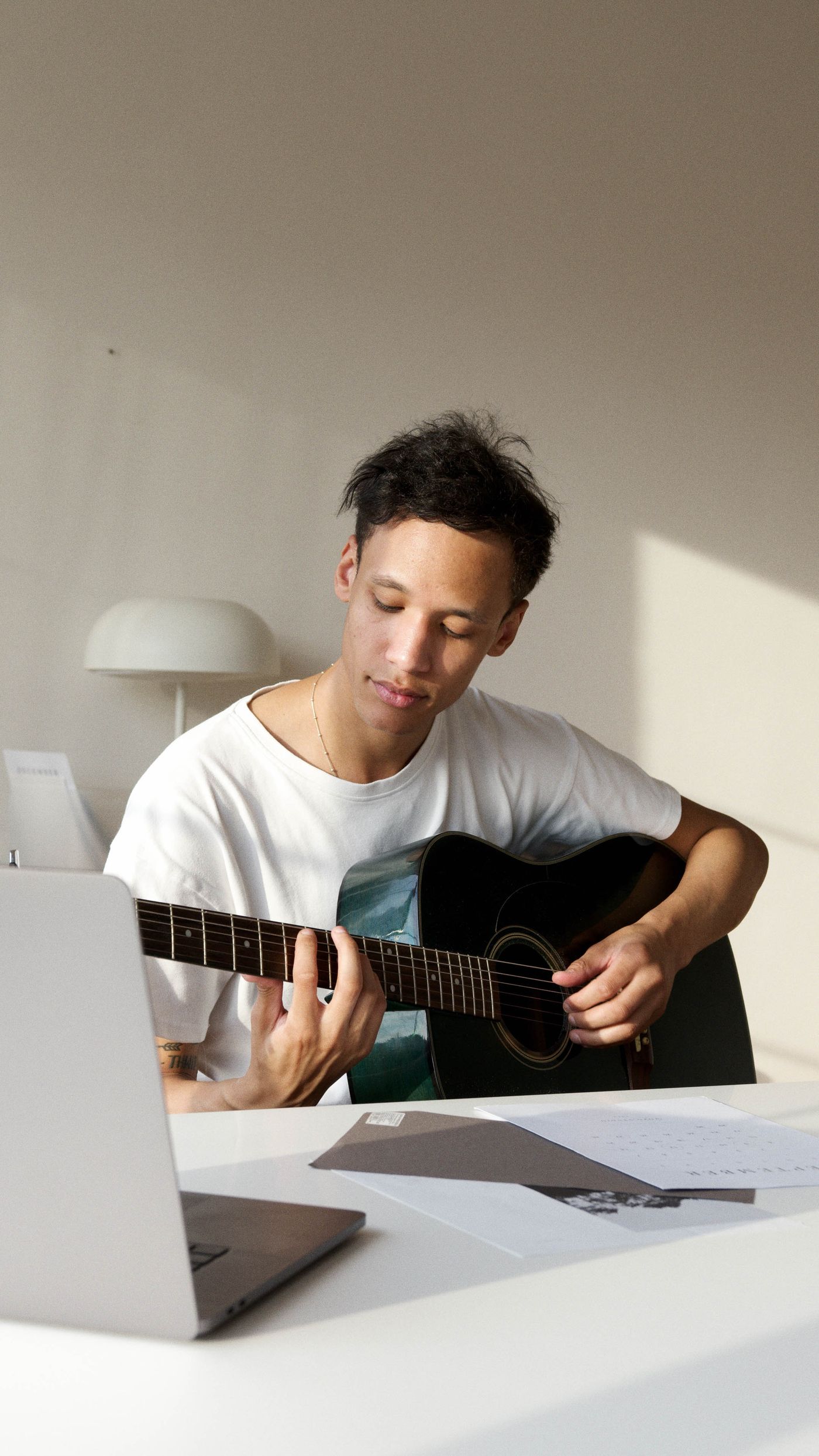 Práctica de guitarra frente a una computadora