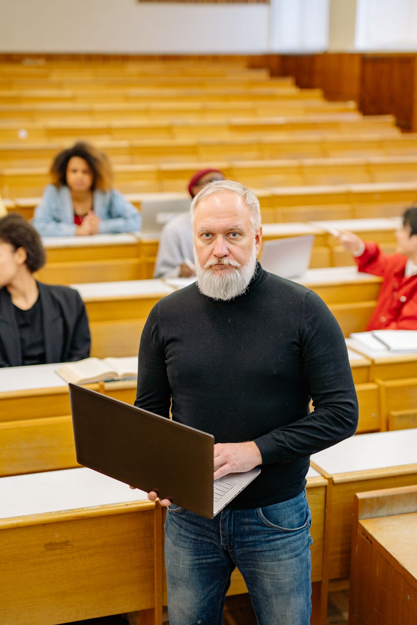 Profesor con computadora en un aula